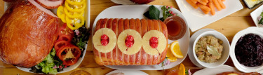 a ham with sliced pineapples and cherries on top