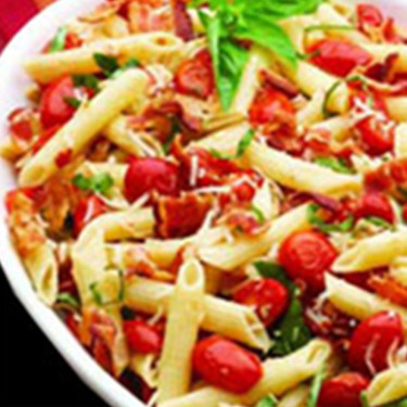 a dish of pasta with bacon and roasted tomatoes