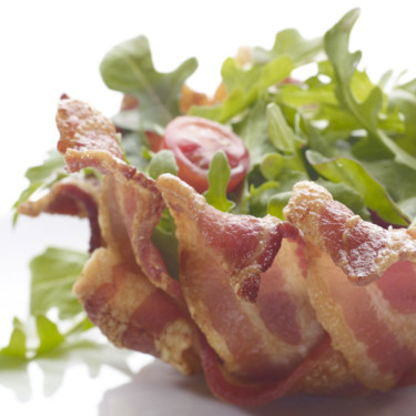 a bowl made of bacon filled with salad
