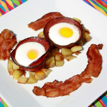 eggs, bacon and potatoes in the shape of a smiley face