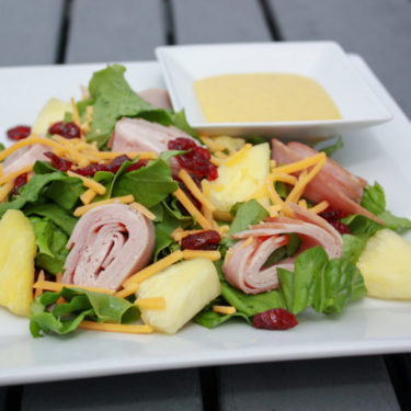 Hawaiian Salad with dressing on the side on a plate